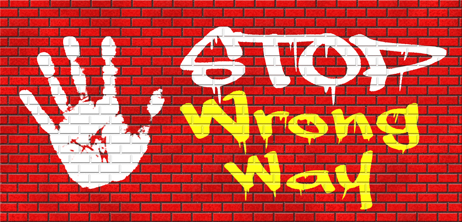 wrong way stop and take a uturn making a mistake turn back now bad direction graffiti on red brick wall, text and hand
